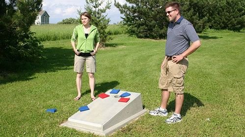 a man and a woman standing on a grass field